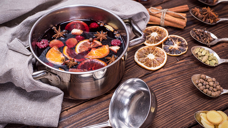 Roter Glühwein im Topf mit Gewürzen