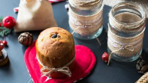 Mini panettone with Christmas decoration, on different wood background