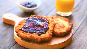 Zwei Teigfladen mit Marmelade serviert auf einem Holzbrett.