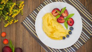 Muas angerichtet auf einem Teller mit frischen Früchten und flüssiger Butter