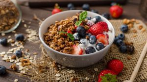 Eine Schüssel mit Joghurt und Früchten zusammen mit einer Portion Granola.