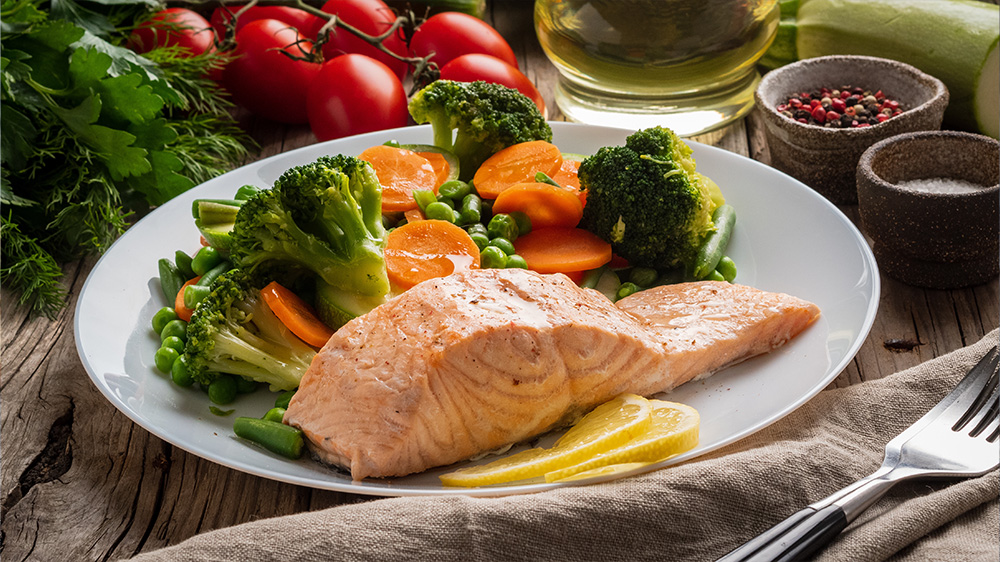 Gedämpfter Lachs mit Gemüse auf einem Teller