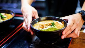 Cook geeting ready the Ramen for serving.