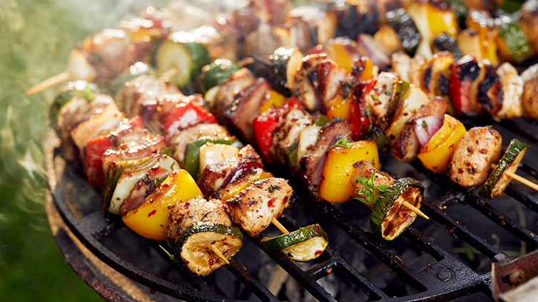 Grillspieße brutzeln auf dem Grill