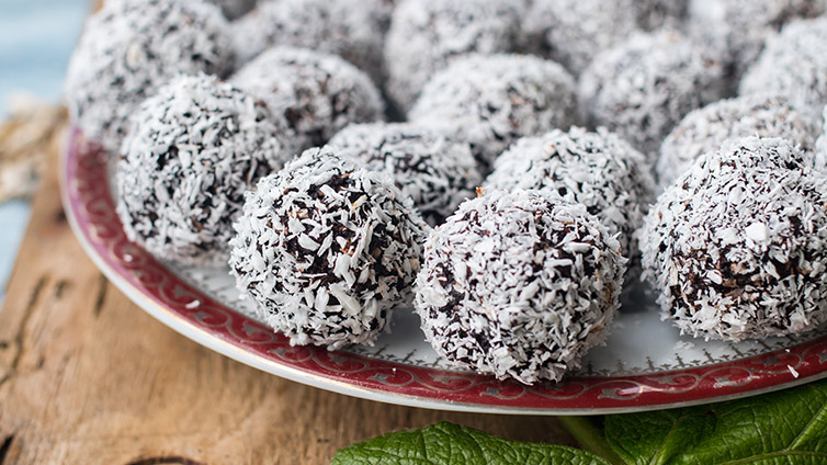 Energyballs auf dem Teller mit Kokosflocken