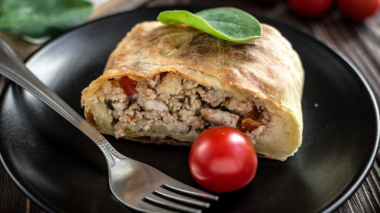 Strudel mit Hühnchen und Tomate auf Teller