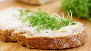 Scheibe Joghurt-Krustenbrot mit Butter und Kresse