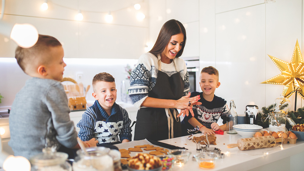 Mutter mit drei Söhnen in der Küche für Weihnachtsessen