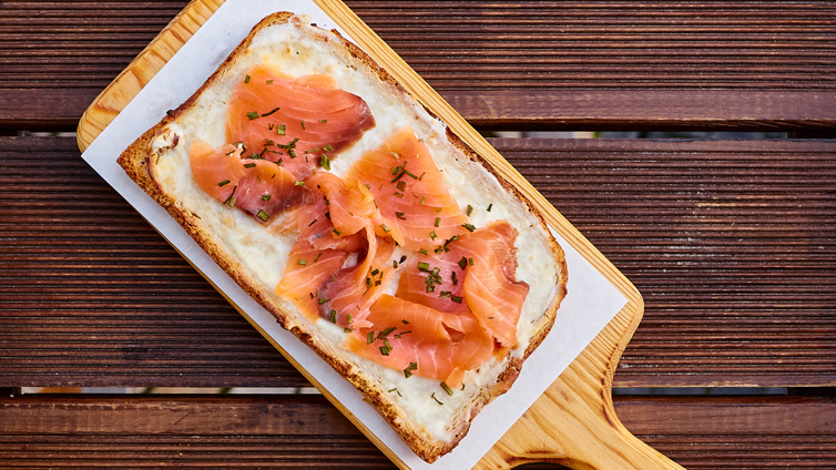 Flammkuchen Toast mit Lachs auf Holzbrett