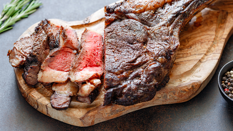 Tomahawk-Steak gegrillt auf Holzbrett