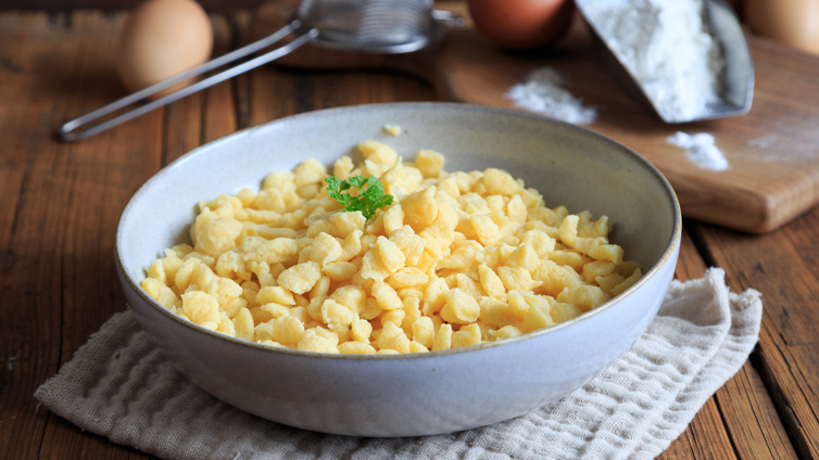 Selbst gemachte Spätzle oder Knöpfle werden in einer flachen Schüssel angerichtet.