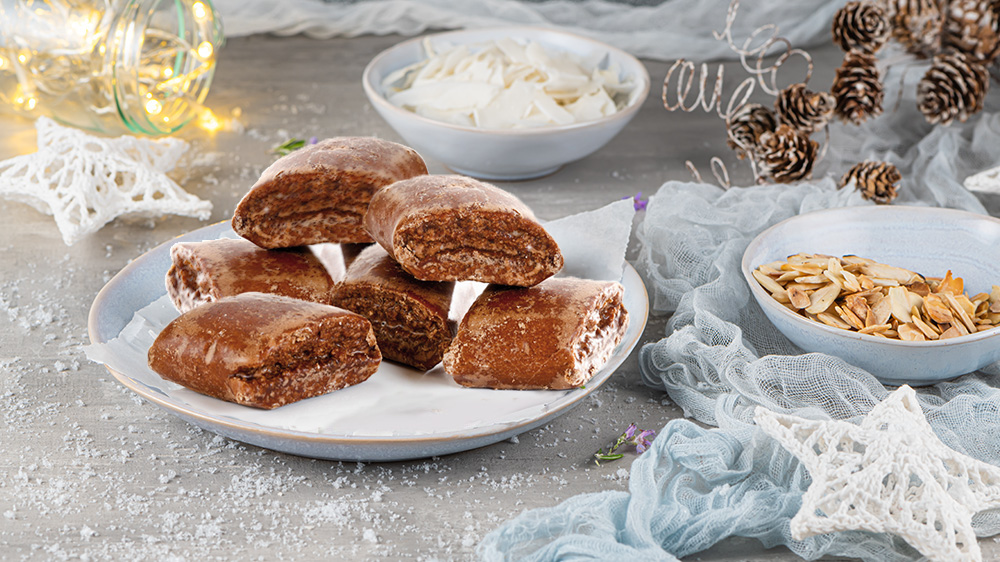 Magenbrot liegt auf einem weihnachtlich geschmückten Tisch.